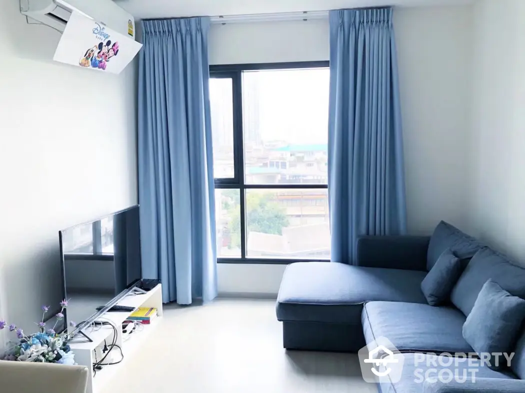 Bright modern living room with blue curtains and sectional sofa, city view window.