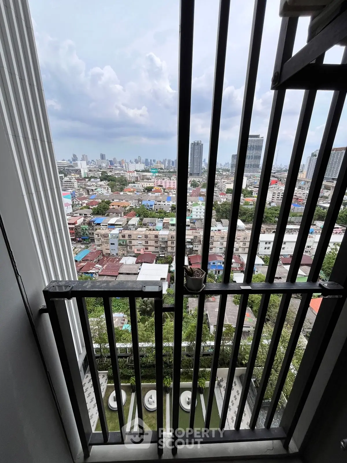 Stunning cityscape view from a high-rise balcony with modern railing design.