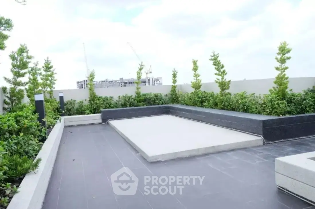 Modern rooftop terrace with lush greenery and city skyline view