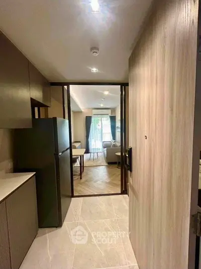Modern apartment entrance leading to a cozy living room with stylish decor and natural light.