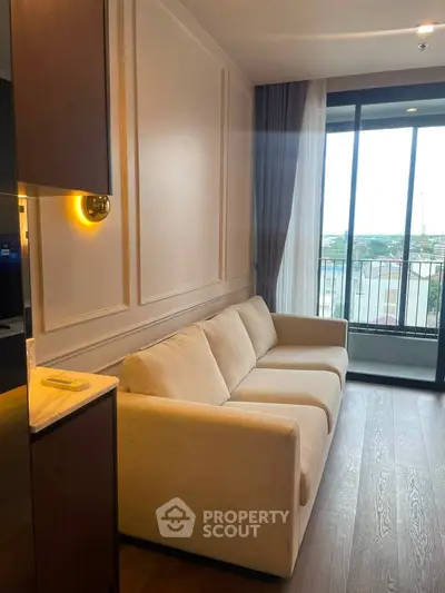 Elegant living room with modern sofa and large window offering a scenic view, perfect for relaxation.