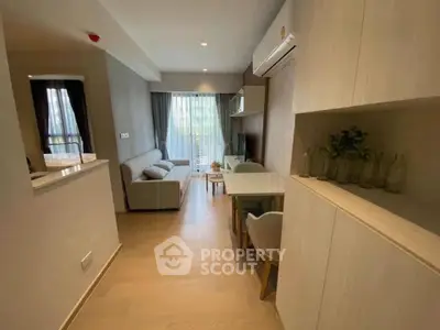 Modern living room with open layout and stylish decor, featuring a cozy sofa and dining area.