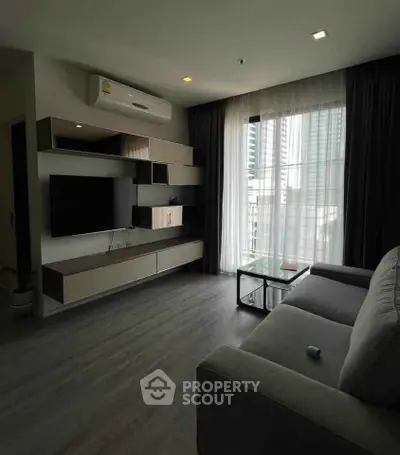 Modern living room with sleek furniture and large window offering city view
