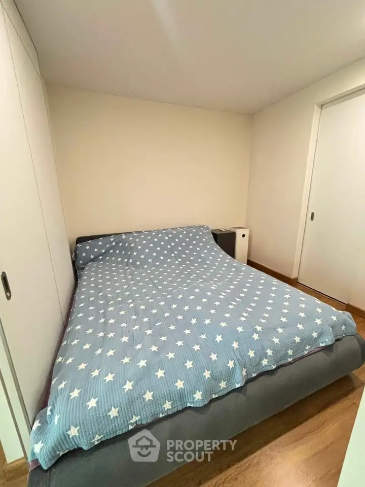 Cozy bedroom with star-patterned bedding and sliding closet doors, perfect for restful nights.