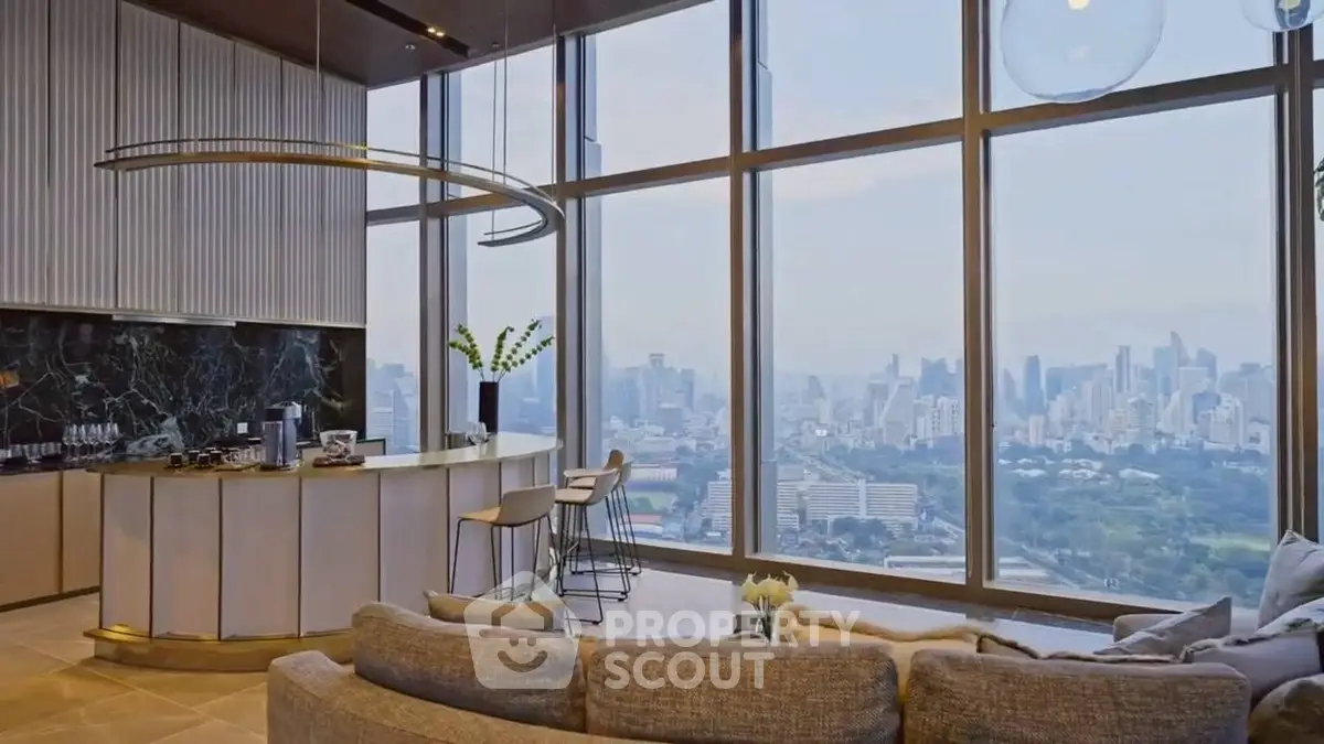 Luxurious living room with panoramic city view and modern open kitchen.
