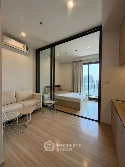 Modern studio apartment with open layout and city view, featuring cozy living area and bedroom.