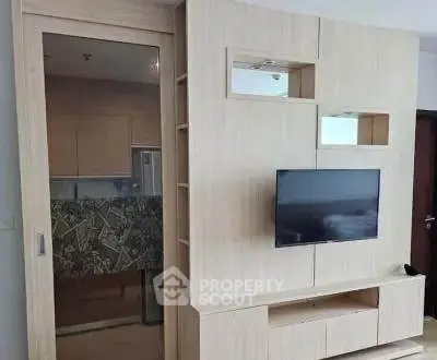 Modern living room with sleek wooden TV unit and glass sliding door to kitchen.