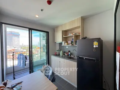 Modern kitchen with balcony view in high-rise apartment, featuring sleek cabinetry and appliances.