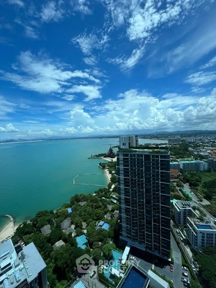 Stunning high-rise view of ocean and cityscape under a vibrant blue sky, perfect for luxury living.