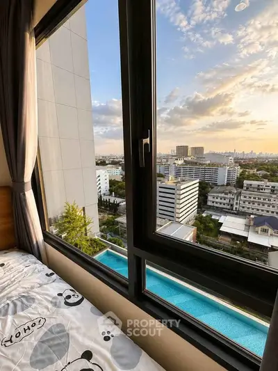 Stunning cityscape view from a modern bedroom window overlooking a pool and skyline.