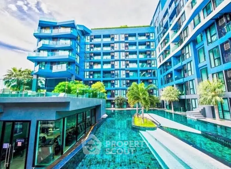 Stunning modern apartment complex with vibrant blue facade and luxurious pool area.