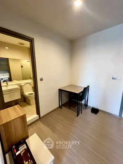 Compact apartment interior with dining area and bathroom view