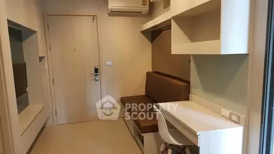 Modern study area with built-in desk and seating in compact apartment.