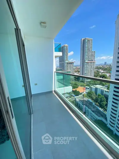 Stunning high-rise balcony with breathtaking city views and modern glass railing.