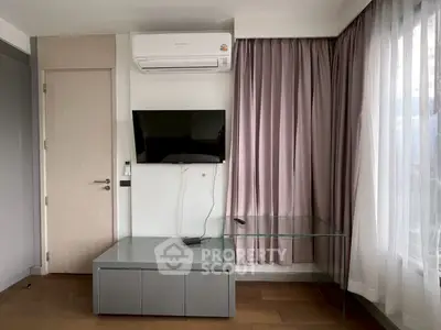 Modern living room with wall-mounted TV and air conditioning, featuring elegant curtains and sleek furniture.