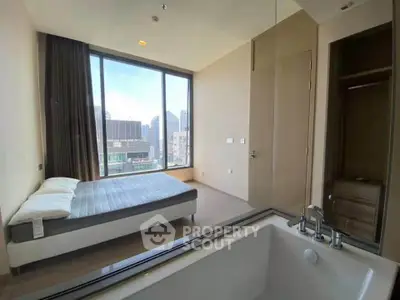 Modern bedroom with large windows and city view, featuring a bathtub for luxurious living.