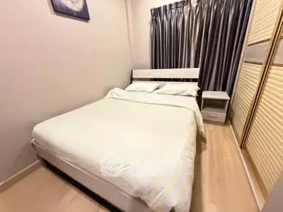 Cozy bedroom with modern decor and ample natural light, featuring a comfortable bed and stylish curtains.