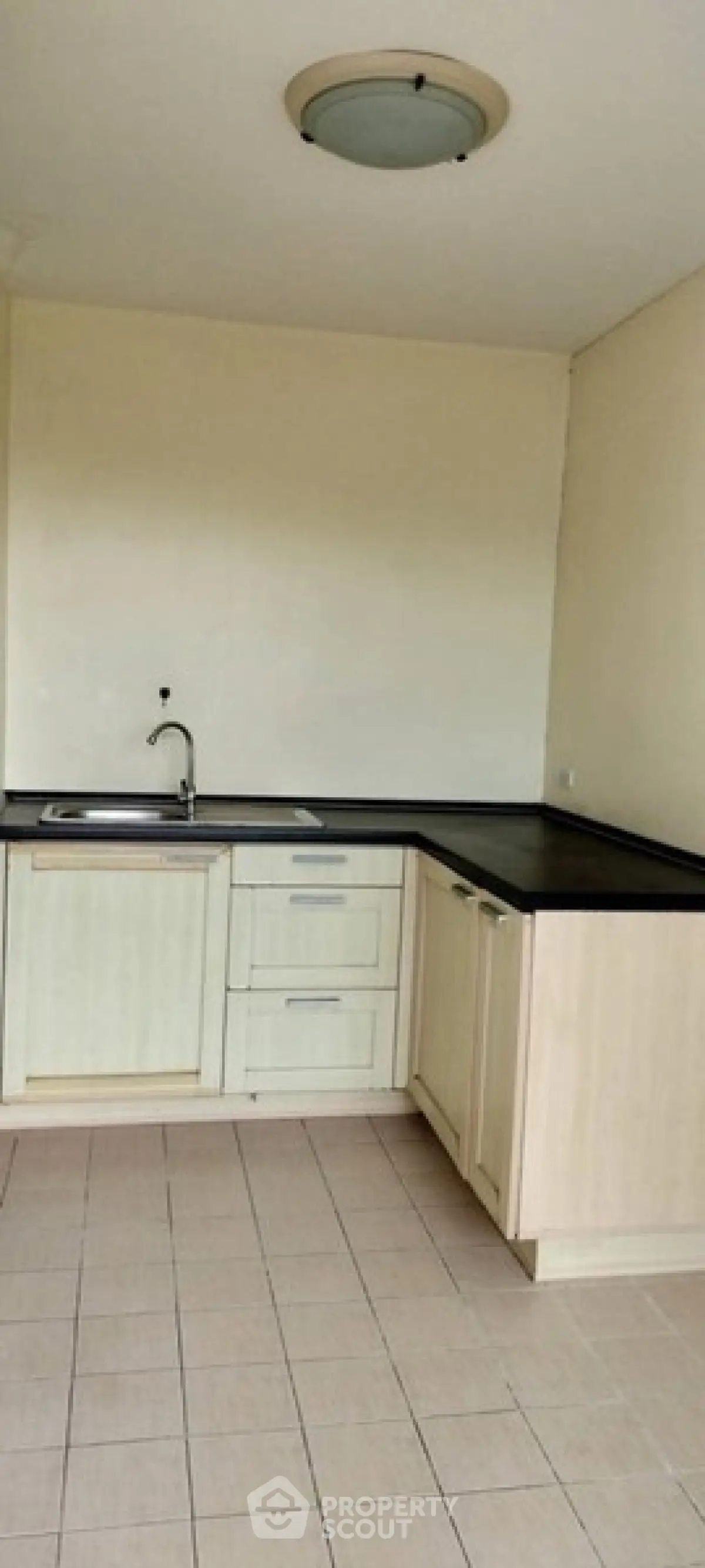Spacious kitchen with modern cabinetry and sleek countertops in a contemporary apartment.