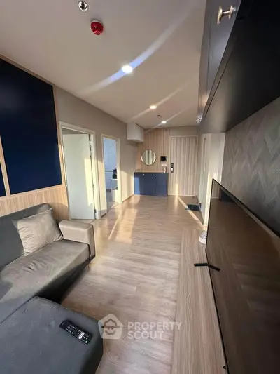 Modern living room with sleek design and ample natural light, featuring a comfortable sofa and stylish decor.