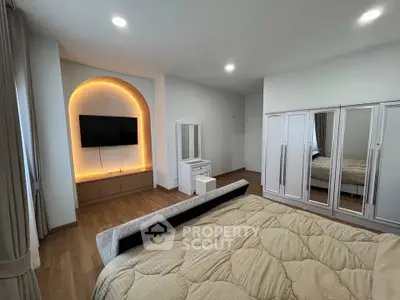 Spacious bedroom with modern decor and built-in TV unit