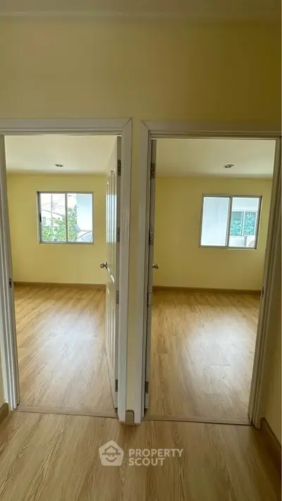 Spacious dual-entry rooms with wooden flooring and ample natural light.