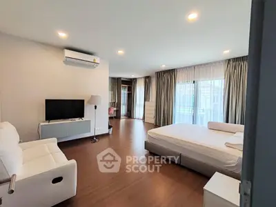 Spacious modern bedroom with natural light and stylish furnishings