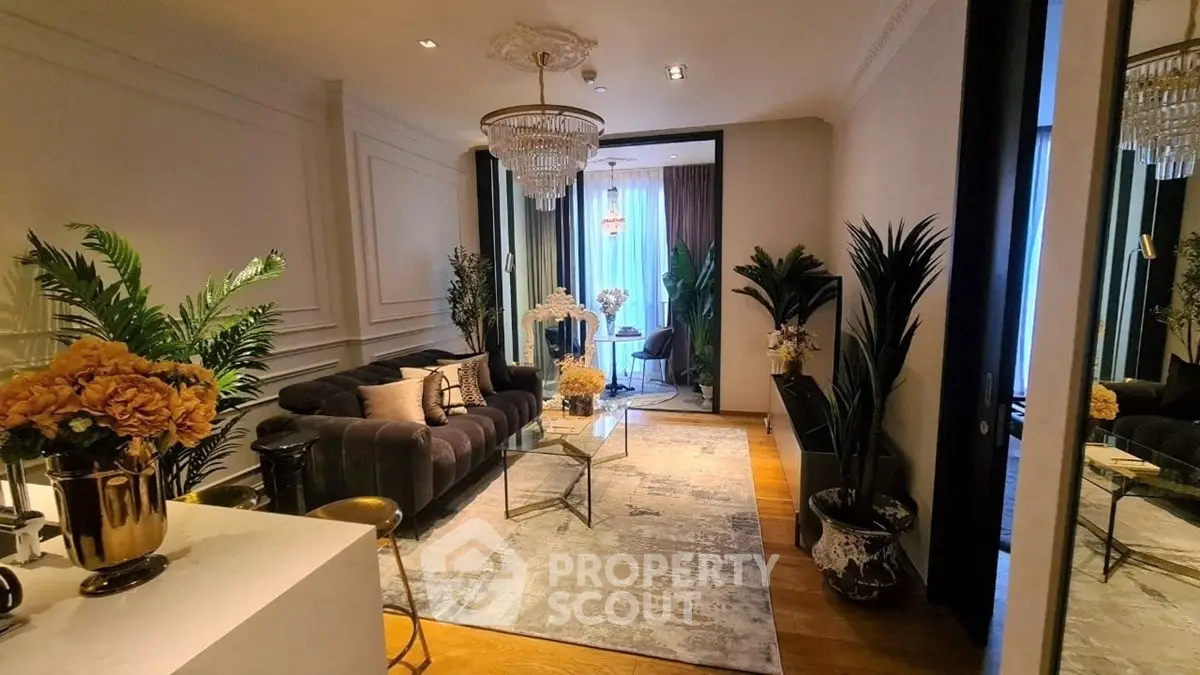 Luxurious living room with elegant decor, plush sofa, and chandelier lighting in a modern apartment.