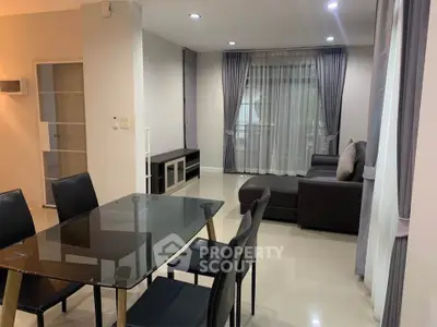 Modern living room with sleek furniture and dining area in open layout.
