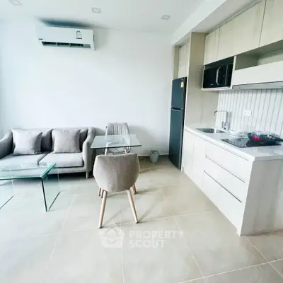 Modern open-plan living room and kitchen with sleek design and neutral tones.