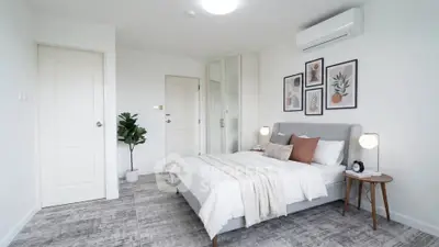 Modern bedroom with stylish decor and air conditioning in a bright, minimalist design.