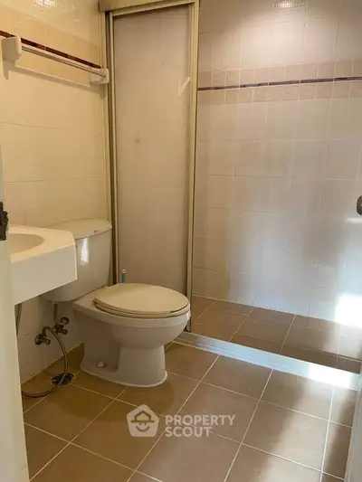 Modern bathroom with sleek design and tiled shower area in a real estate property.