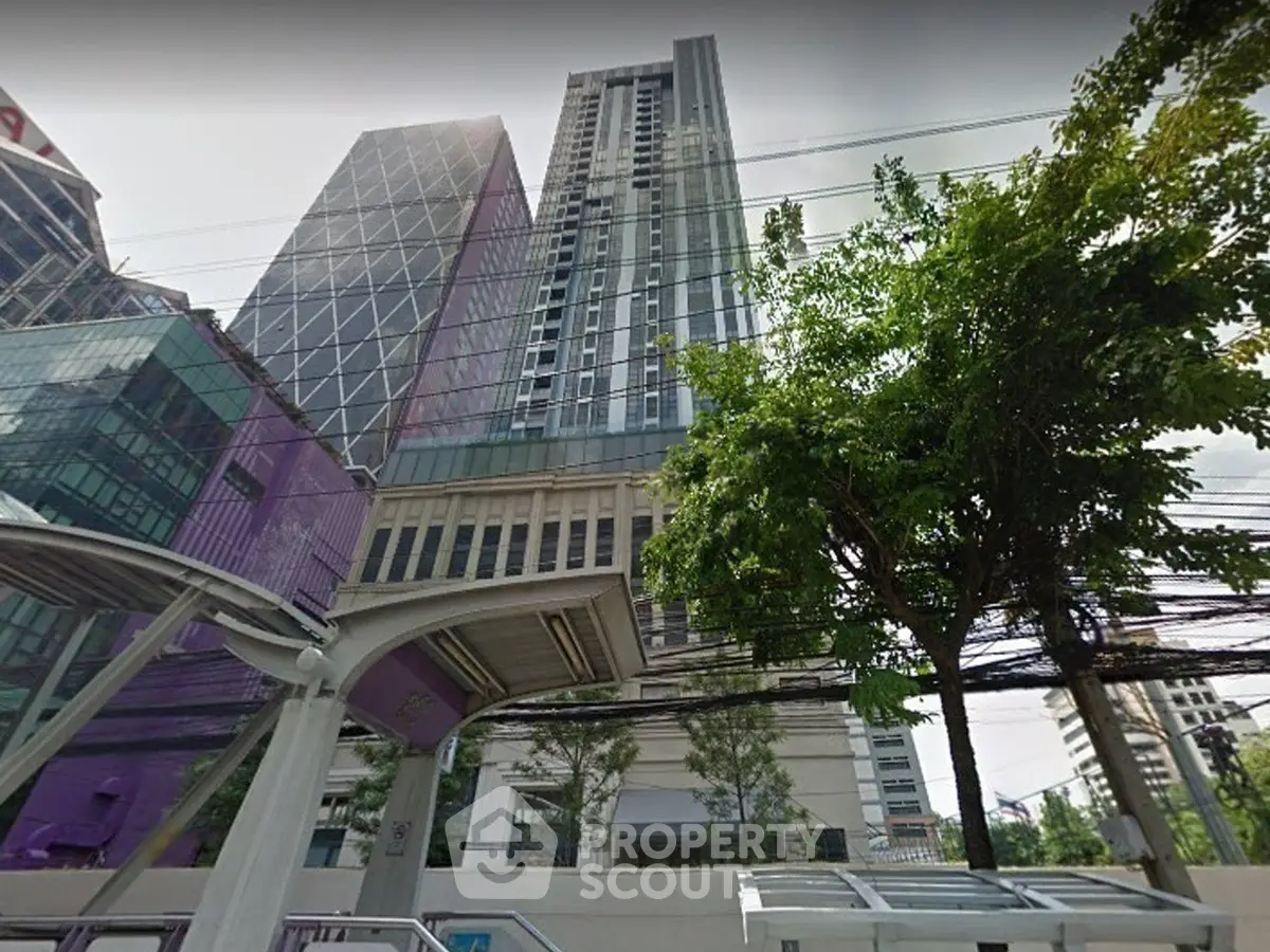 Stunning high-rise building with modern architecture and lush greenery in urban setting.