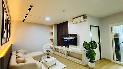 Modern living room with stylish decor, cozy sofa, and wall-mounted TV, perfect for relaxation and entertainment.