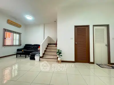Spacious living room with modern staircase and cozy seating area