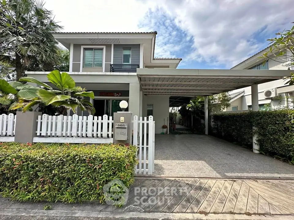 Charming two-story house with lush garden and spacious driveway in a serene neighborhood.
