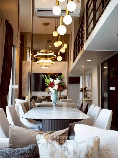 Luxurious modern dining area with elegant lighting and stylish decor in a spacious open-plan living space.