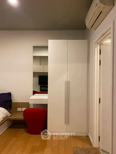 Modern bedroom with sleek wardrobe and cozy red chair