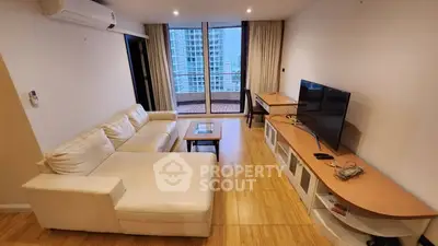 Spacious living room with modern furniture and balcony view in high-rise apartment.