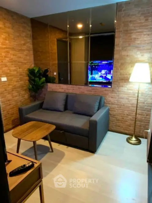 Cozy living room with brick walls, modern sofa, and stylish floor lamp