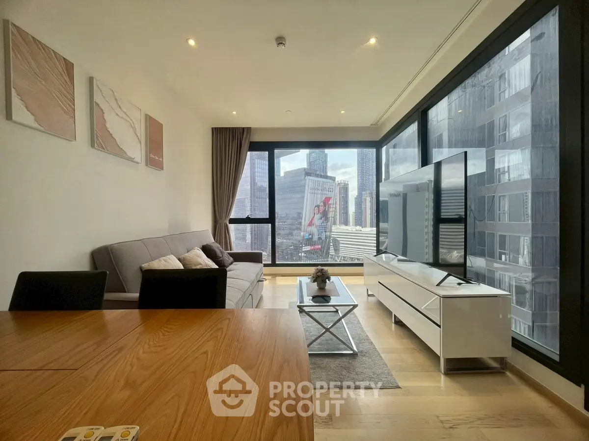 Modern living room with large windows offering stunning city views, stylish furniture, and contemporary decor.