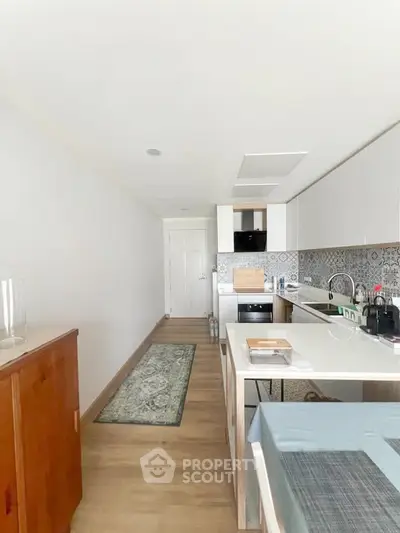 Modern kitchen with sleek cabinetry and stylish backsplash in a bright, open layout.