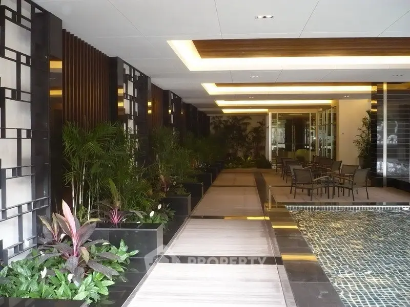 Luxurious indoor pool area with modern design and lush greenery in a high-end residential building.