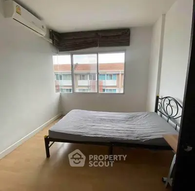 Spacious bedroom with large window and air conditioning in modern apartment