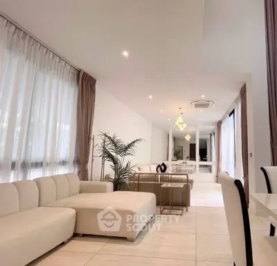 Spacious modern living room with elegant decor and large windows for natural light.