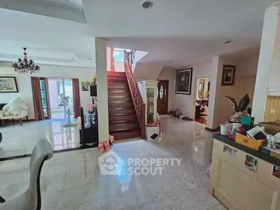 Spacious open-plan living area with elegant staircase and modern decor