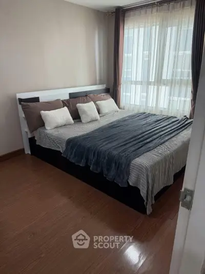 Cozy bedroom with large bed and natural light from window, perfect for relaxation.