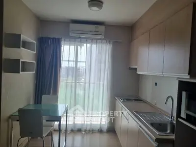 Modern kitchen with dining area and large window offering natural light