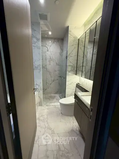 Luxurious marble bathroom with modern fixtures and glass shower enclosure
