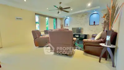 Spacious living room with modern decor and ceiling fan, perfect for relaxation and entertainment.