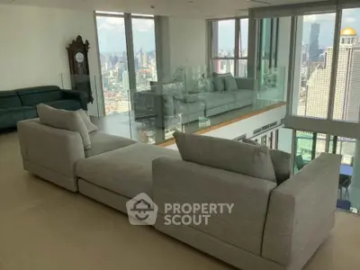 Luxurious modern living room with panoramic city views and elegant gray sofas.
